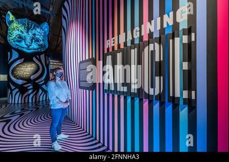Londra, Regno Unito. 18 maggio 2021. Reinventare Alice con il Cheshire Cat - un'installazione d'arte digitale ispirata al vetro ‘look', che incoraggia i visitatori a immaginare le proprie meraviglie - Alice: Curiouser e Curiouser mostra al V&A, si apre come blocco facilita ulteriormente. Celebrando la storia iconica, fantasiosa e stimolante, il V&A è il primo museo ad esplorare appieno l'impatto culturale di Alice nel paese delle meraviglie e la sua continua ispirazione per i migliori creativi, da Salvador Dalí e Yayoi Kusama, ai Beatles, Vivienne Westwood e Little Sitz. La mostra è stata progettata da un premiato designer Foto Stock