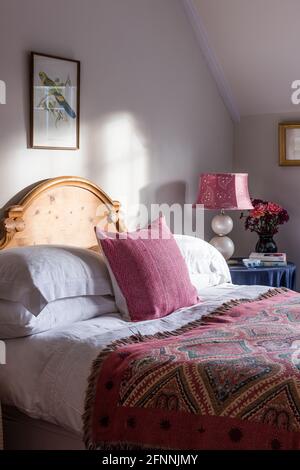 Coperta arazzo su letto matrimoniale illuminato al sole in cottage vittoriano del 19 ° secolo. Foto Stock