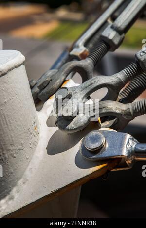 Dettaglio di un tenditore per corda metallica. Tenditore in acciaio, concetto di fissaggio e collegamenti, fuoco selettivo. Foto Stock