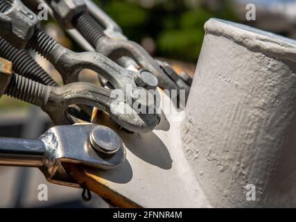 Dettaglio di un tenditore per corda metallica. Tenditore in acciaio, concetto di fissaggio e collegamenti, fuoco selettivo. Foto Stock