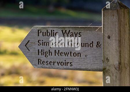 Segnaletica per vie pubbliche a Cumbria, Inghilterra. Il cartello indica la strada per Simpson Ground e High Newton Reservoir. Foto Stock