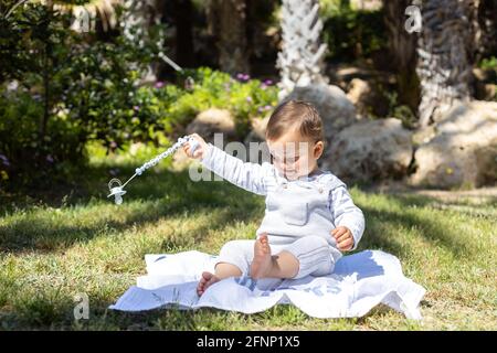 Un ragazzino seduto sull'erba. Foto Stock