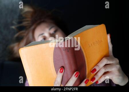 Donna che legge la bibbia a casa. Francia. Foto Stock