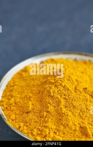 Primo piano immagine della polvere curcuma in una ciotola, profondità di campo poco profonda, spazio per il testo. Foto Stock