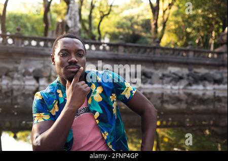 Un giovane uomo nero nel parco. Ritratto esterno del viaggiatore. Verticale Foto Stock