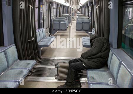 Un uomo senza dimora che dorme in una metropolitana di Parigi, in Francia Foto Stock