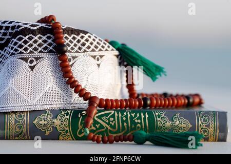 Corano, cappellino Kufi e perle di preghiera ( misbaha ) . Simboli dell'Islam. Emirati Arabi Uniti Foto Stock