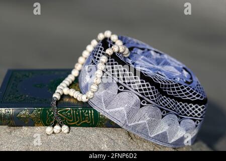 Corano, cappellino Kufi e perle di preghiera ( misbaha ) . Simboli dell'Islam. Emirati Arabi Uniti Foto Stock