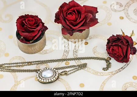 Gioielli e fiori. Collana e rose rosse Foto Stock