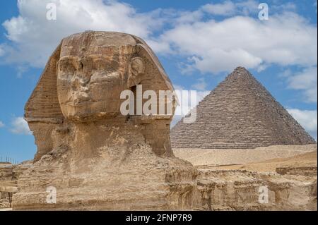 La faccia anteriore e il corpo della Sfinge e la Grande Piramide più grande di Khafre appaiono fianco a fianco nel deserto di Giza, il Cairo, Egitto. Copia orizzontale Foto Stock