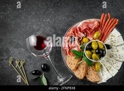 Antipasti di fondo con bicchiere di vino rosso. Overhead, spazio di copia. Foto Stock