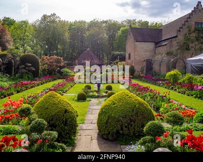 Chenies Manor Sunken giardino nel tardo pomeriggio luce, di fronte a ovest. Il vecchio Padiglione restaurato uno sfondo di tulipani colorati di arancio, rosso e viola. Foto Stock