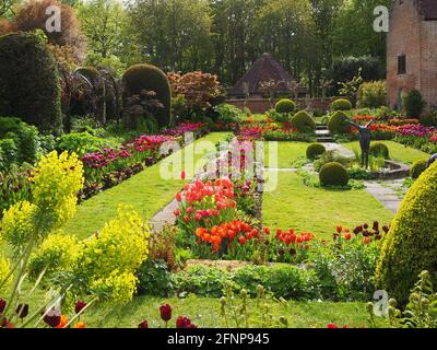 Chenies Manor Sunken giardino nel tardo pomeriggio luce, di fronte a ovest. Il vecchio Padiglione restaurato uno sfondo di tulipani colorati di arancio, rosso e viola. Foto Stock