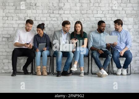 Diverse coppie di utenti di gadget millenari che condividono contenuti su tablet Foto Stock