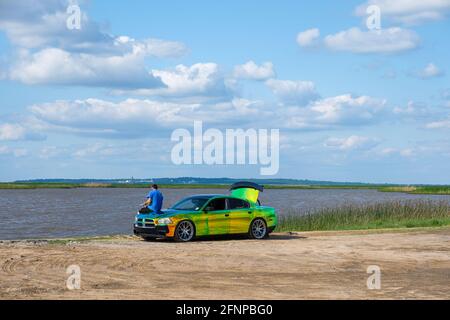 CYPREMORT POINT STATE PARK, LA, USA - 13 MAGGIO 2021: L'uomo pesca dal cofano di un'auto personalizzata con un lavoro di verniciatura a colori variabile Foto Stock