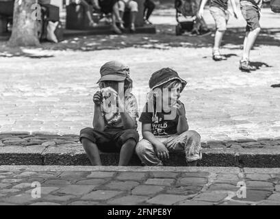 Due ragazzi si sedettero a guardare la vita di strada Foto Stock