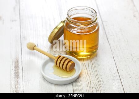miele in vaso di vetro con cucchiaino di miele in legno Foto Stock