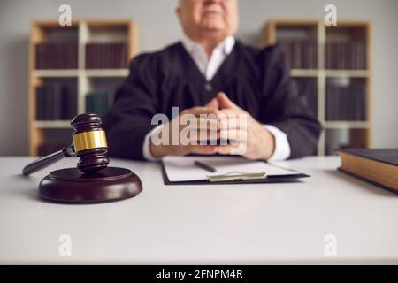 Primo piano di un gavel di legno che giace su un blocco sonoro su un banco di giudici nel cortile. Foto Stock