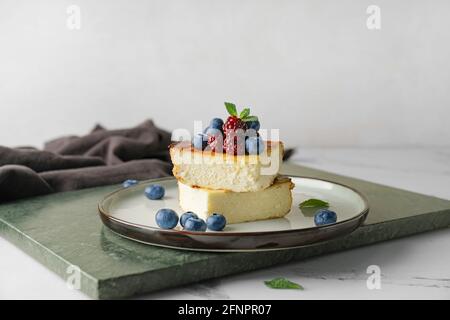 Piatto con pezzi di caseruola di formaggio cottage sul tavolo Foto Stock