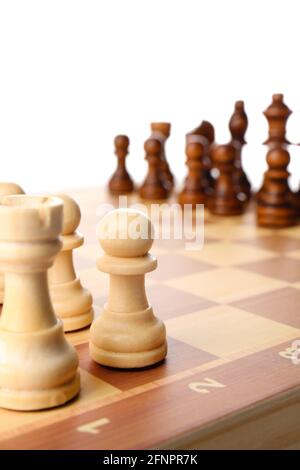 Tavolo da gioco con pezzi di scacchi su sfondo bianco Foto Stock
