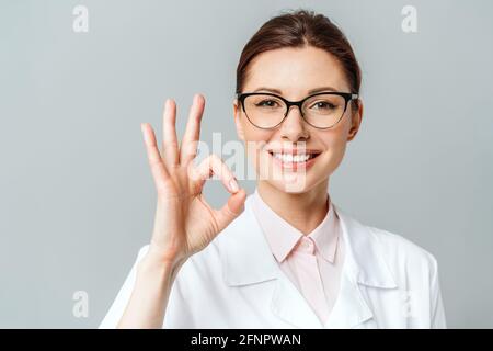 Ritratto di una donna felice medico che mostra il segno OK Foto Stock