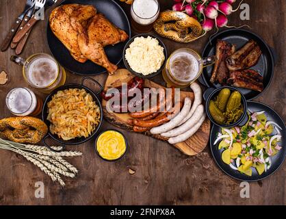 Piatti Oktoberfest con birra, pretzel e salsiccia Foto Stock