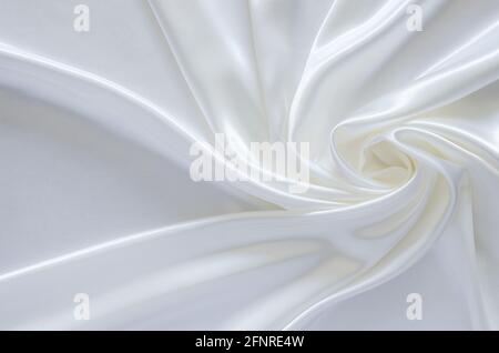 Elegante tessuto satinato bianco ondulato e liscio. Astratto, struttura e concetto di matrimonio. Foto Stock