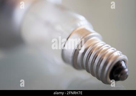 Primo piano del montaggio di una lampadina su un vetro grigio tabella Foto Stock