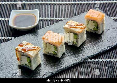 Philadelphia con un cetriolo su una pietra scura. Sushi giapponese. Foto Stock