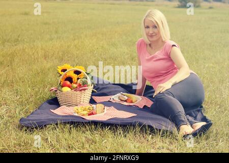 Donna slovena incinta che fa un picnic nel campo Foto Stock