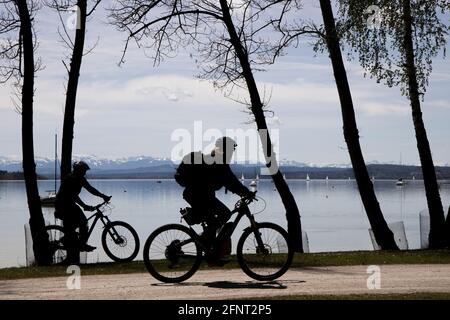 Coppia in bicicletta sulla riva del lago Ammer a Herrsching, alta Baviera, Germania, Europa. Foto Stock