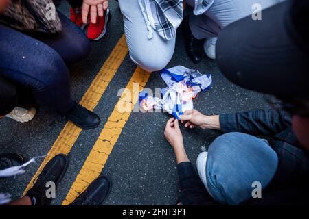 Washington, DC, USA, 18 maggio 2021. Nella foto: I dimostranti bruciano una bandiera israeliana durante una marcia contro le azioni di Israele a Gaza e a Gerusalemme dall’ambasciata israeliana alla Casa Bianca. Credit: Alison Bailey / Alamy Live News Foto Stock