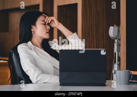 Donna d'affari ottiene stressata e mal di testa mentre ha un problema. Foto Stock