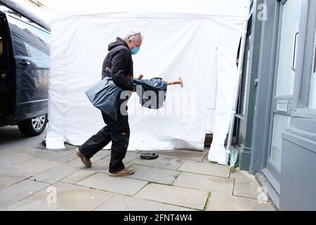 Gloucester, Gloucestershire, Regno Unito - Mercoledì 19 maggio 2021 - gli ufficiali forensi della polizia arrivano con le attrezzature di scavo al caffè di piastra pulita come gli scavi iniziano come la ricerca della polizia per Mary Bastholm che è andato scomparendo in 1968 di età appena 15 anni e che può essere stata una vittima del serial killer Fred West. Spettacoli fotografici ufficiali di polizia di fronte al locale caffè alle 9.30:00. Photo Steven May / Alamy Live News Foto Stock