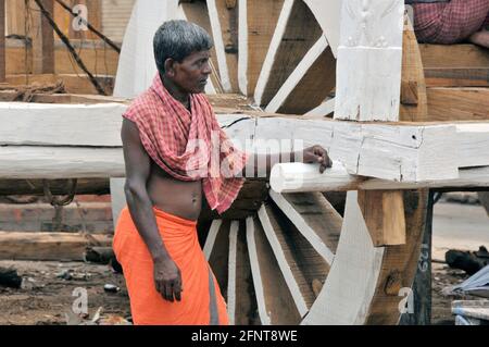 Un artista si trova di fronte al carro semilavorato. Prima del festival dei carri, è in corso il lavoro per la realizzazione del carro a Puri. Foto Stock