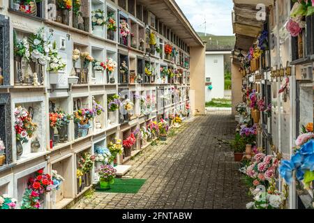 Il rispetto per i morti è rappresentato dall'enorme quantità di fiori che il luogo vivente di fronte alle lapidi. Abruzzo, Italia, Europa Foto Stock