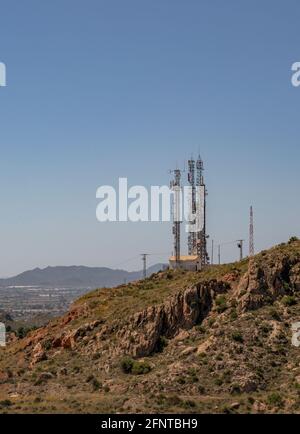 Antenna telefono e torri di comunicazione sullo sfondo di una bella montagna e un bel cielo. Può essere utilizzato come sfondo o paesaggio. Foto Stock