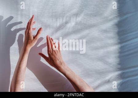 Mano della donna che si allunga su sfondo bianco. Foto Stock