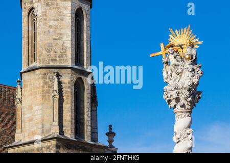 Parte superiore della statua barocca della Santissima Trinità e campanile della chiesa benedettina o della Beata Maria, Sopron, Ungheria Foto Stock