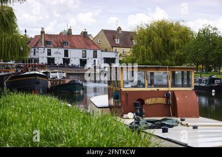Cottage e chiatte in primavera guardando verso il ristorante e bar Cutter Inn sul fiume Great Ouse a Ely, Cambridgeshire, Inghilterra, Regno Unito Foto Stock