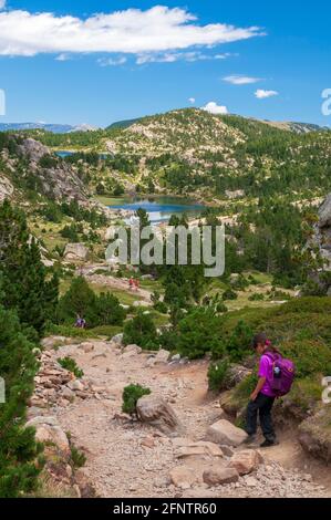 Escursionisti sul sentiero intorno ai laghi Bouillouses, un sito naturale nella regione di Capcir, Parco Naturale Regionale dei Pirenei Catalani, Pirenei Orientali (66 Foto Stock