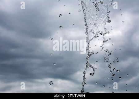 cascata contro il cielo. l'acqua in caduta è congelata nella foto. colpo fresco di acqua spruzzi. Fermati al telaio di una piccola cascata in un parco. Foto Stock