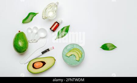 Maschera facciale per la cura della pelle in avocado. Prodotti di bellezza cosmetici naturali biologici olio di avocado, olio essenziale, maschera viso o prodotti da bagno scrub corpo Foto Stock