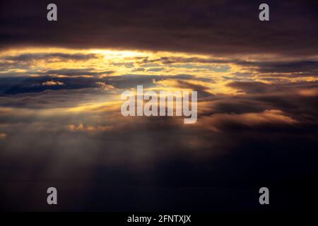 Nuvole nere con raggi . Luce solare che splende dalle nuvole nere . Volare in condizioni climatiche cupe Foto Stock