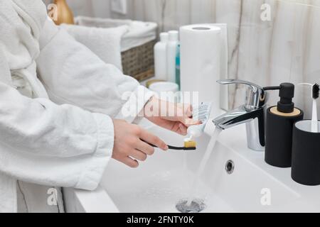 spazzolino da denti femminile con pasta in bagno Foto Stock
