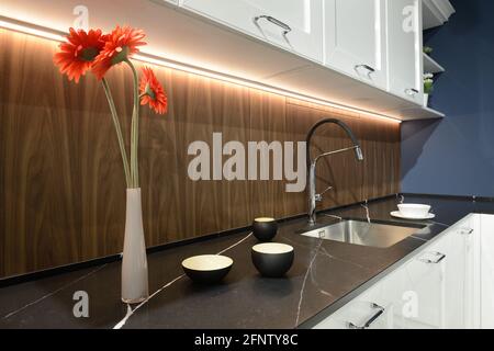 Una nuova, moderna cucina completamente bianca con luci nere appese al  soffitto e sgabelli da bar neri che si siedono al banco per un'area da  pranzo Foto stock - Alamy