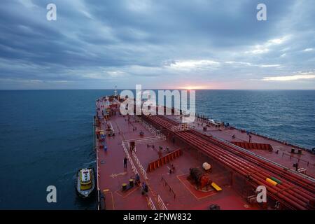 nave cisterna e nave di rifornimento all'ancoraggio sotto le luci del tramonto Foto Stock