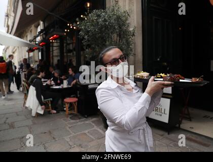 Parigi, Francia. 19 maggio 2021. Una cameriera è occupata sulla terrazza di un ristorante il suo primo giorno di riapertura a Parigi, Francia, 19 maggio 2021. Credit: Gao Jing/Xinhua/Alamy Live News Foto Stock