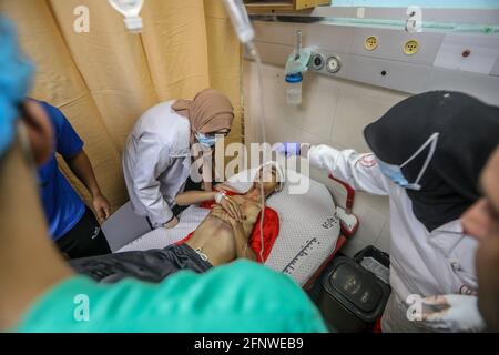 Gaza. 19 maggio 2021. Un bambino palestinese è stato ferito mentre giocava vicino alla porta della sua casa dopo che gli aerei israeliani hanno preso di mira con un certo numero di bambini nel quartiere di al-Zaytoun, ad est della città di Gaza. Foto Stock