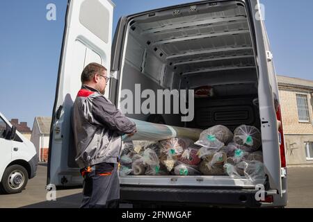 Operatore in piedi vicino a un autocarro pieno di tappeti. Concetto di servizio di pulizia Foto Stock